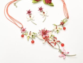 Sött smyckeset med blommor, fjärilar och vackra röda gnistrande kristaller